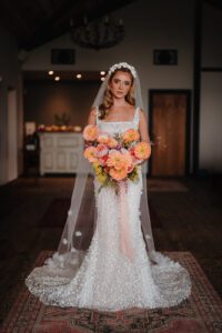 Bride holding flame coloured bouquet