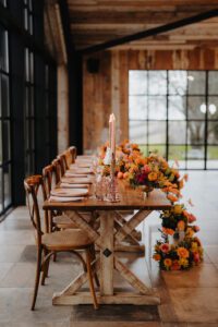Table set for wedding reception decorated with orange blooms